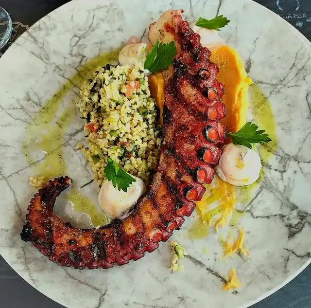 Grilled octopus with a grain salad and orange purée
