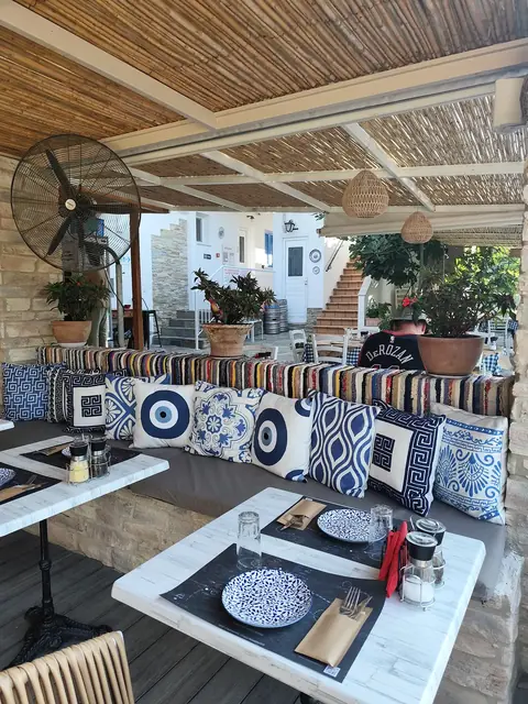 Patterned cushions and set tables under the reed roof