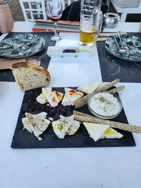 Cheese, dips and fresh bread on a slate board