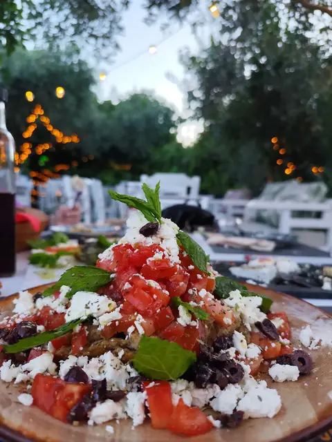 Greek salad with tomato, feta and olives under the trees