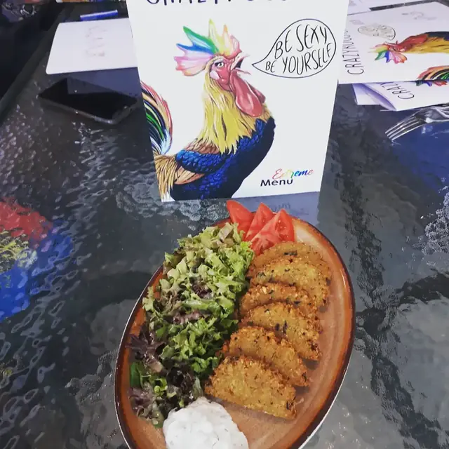 Salad and fritters in front of the rainbow-rooster menu