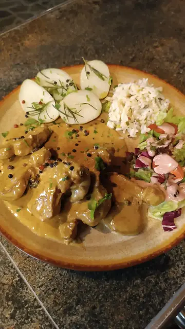 Meat in a creamy sauce with a side of slaw