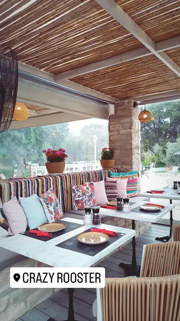 Striped cushions and bright tables under the pergola