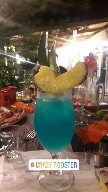 A blue cocktail garnished with pineapple