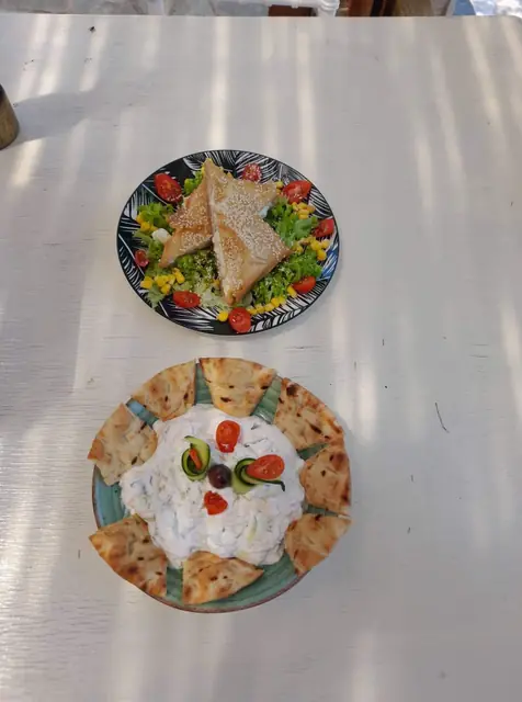 Two plates of starters on a white table