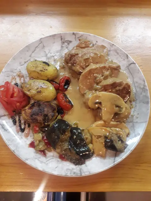 Meatballs, baby potatoes and mushrooms on a speckled plate