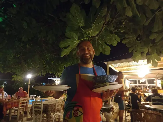 Carrying plates out under the fig tree, the terrace lit up behind