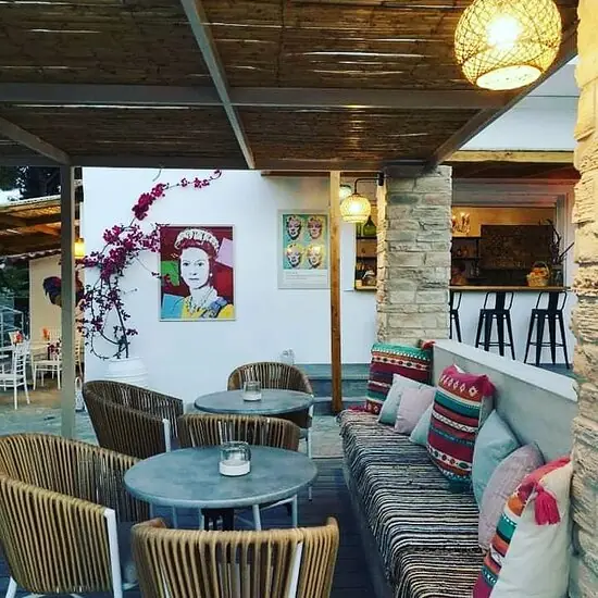 The lounge: striped sofas, bright cushions and a pop-art portrait on the wall