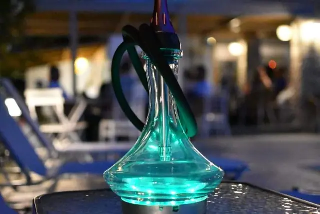 A glowing blue shisha on a table at night
