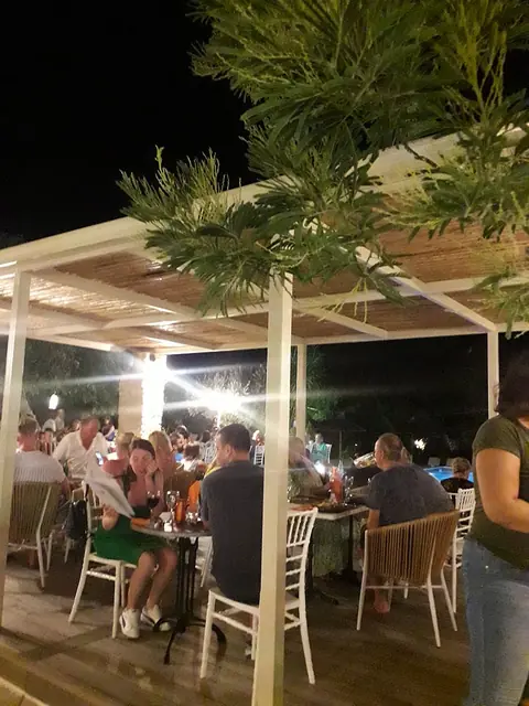 The terrace under the trees at night, every table taken